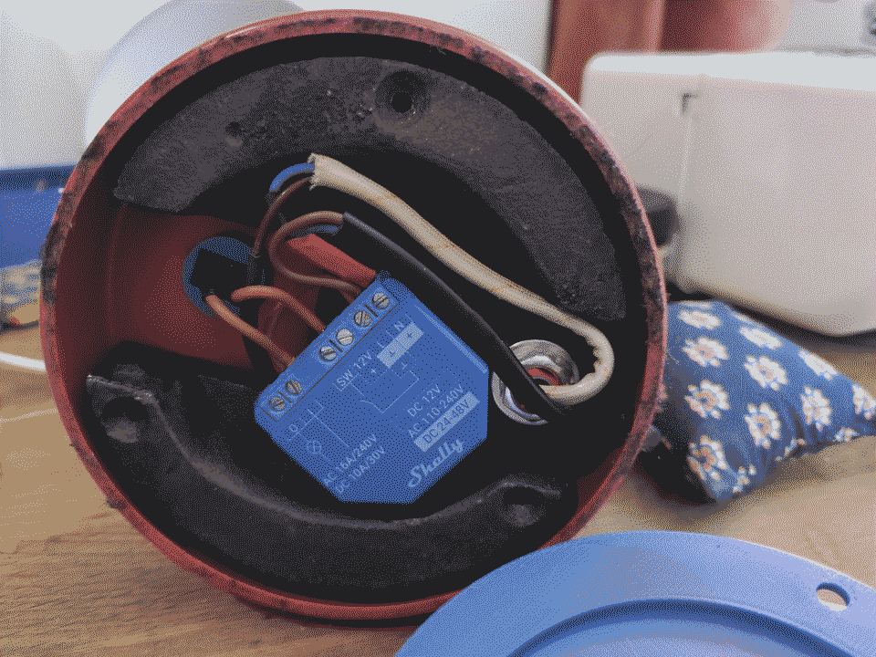 image of shelly device with mains power cable pluged in. The device is enclosed in a black 3d printed case.